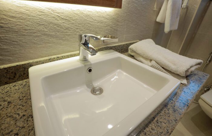 Modern white rectangular sink with a chrome faucet on a granite countertop