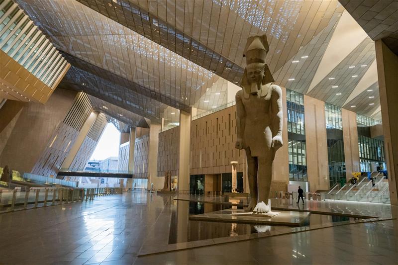 Colossal statue of Ramses II in the modern, angular atrium of the Grand Egyptian Museum