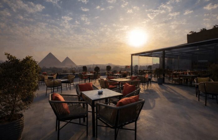Rooftop restaurant patio with a view of the Great Pyramids of Giza at sunset